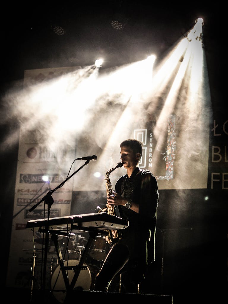 Musician playing saxophone on illuminated stage